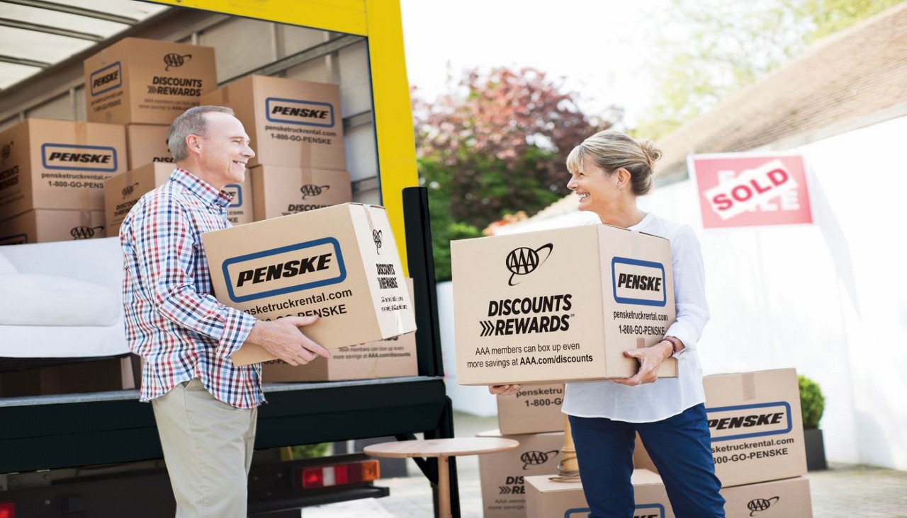 Couple loading moving boxes into a truck 
