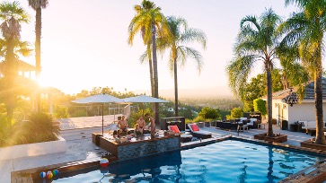 Picture of a group of friends around a swimming pool at a private home.