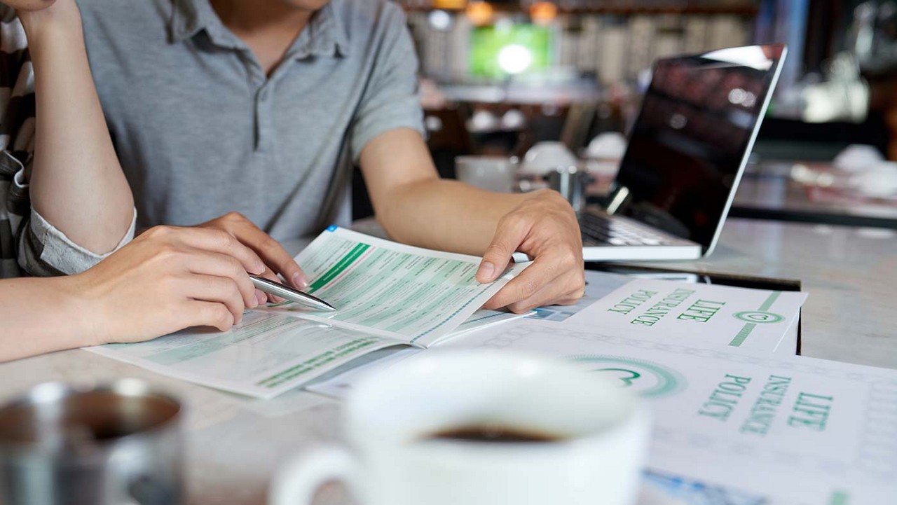 Close up of a man and woman reading through paperwork.