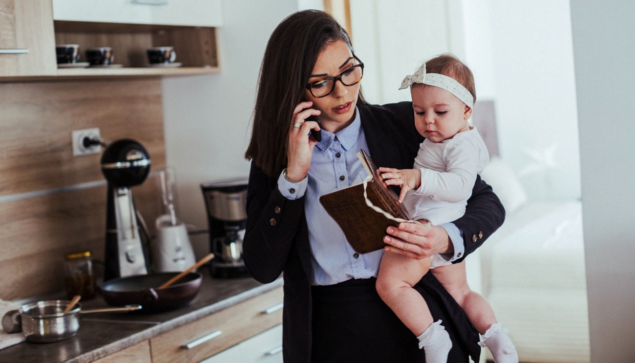 Woman holding a baby while talking on the telephone