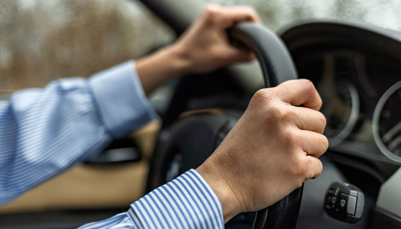 Woman driving a car during the day, side view