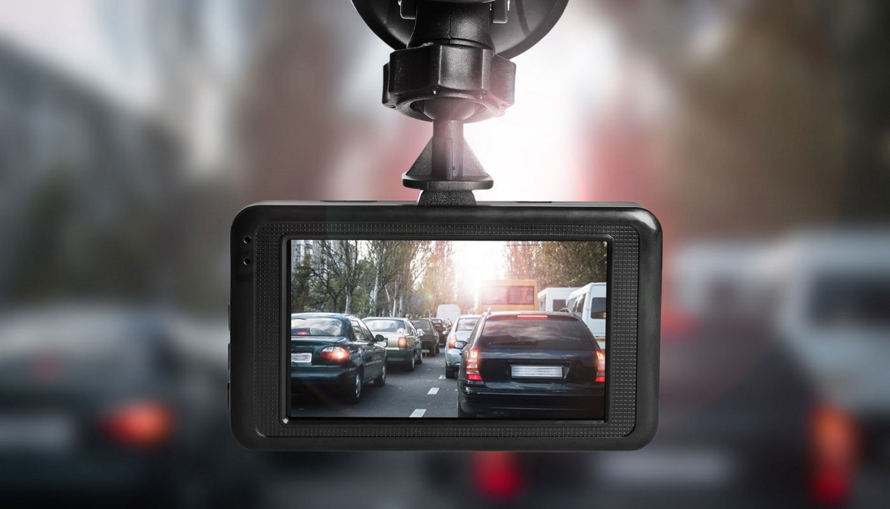 Dashboard camera mounted in car with view of city traffic