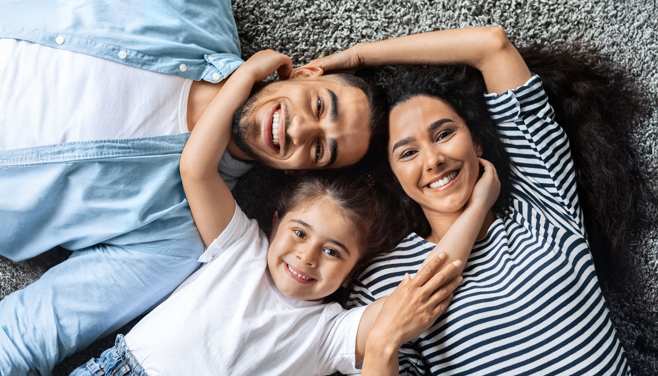 Closeup portrait of happy family posing on floor at home