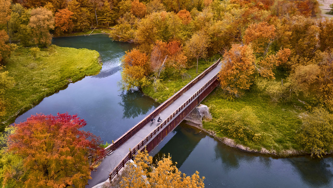 Bridge over a lake with fall foliage all around.